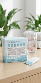 Box of Gluta Collagen with a glass of water and packets on a wooden surface with plants in the background
